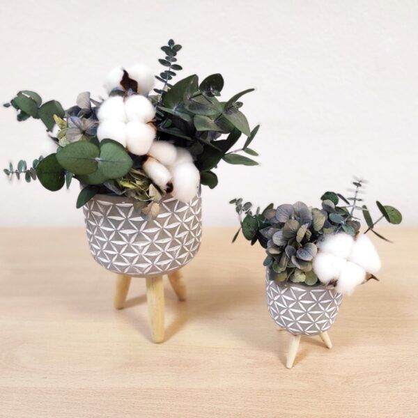 Macetas Twins de cerámica y patas de madera con flores preservadas.