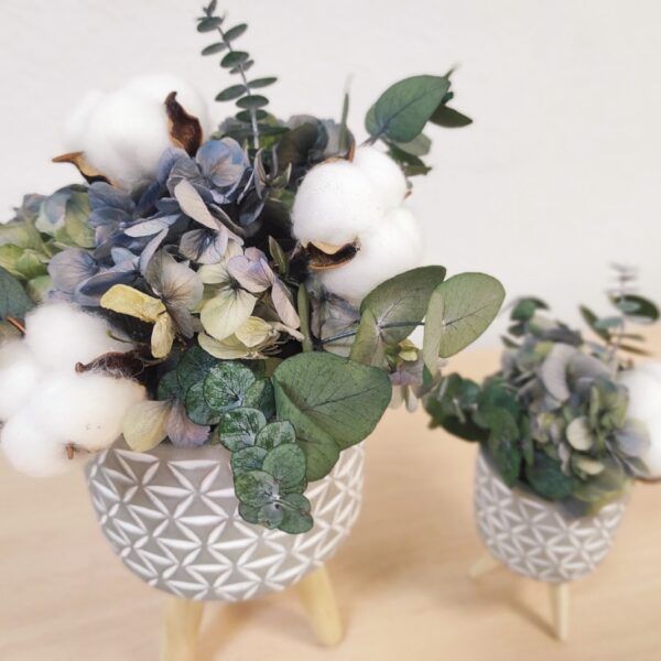 Macetas Twins de cerámica y patas de madera con flores preservadas.
